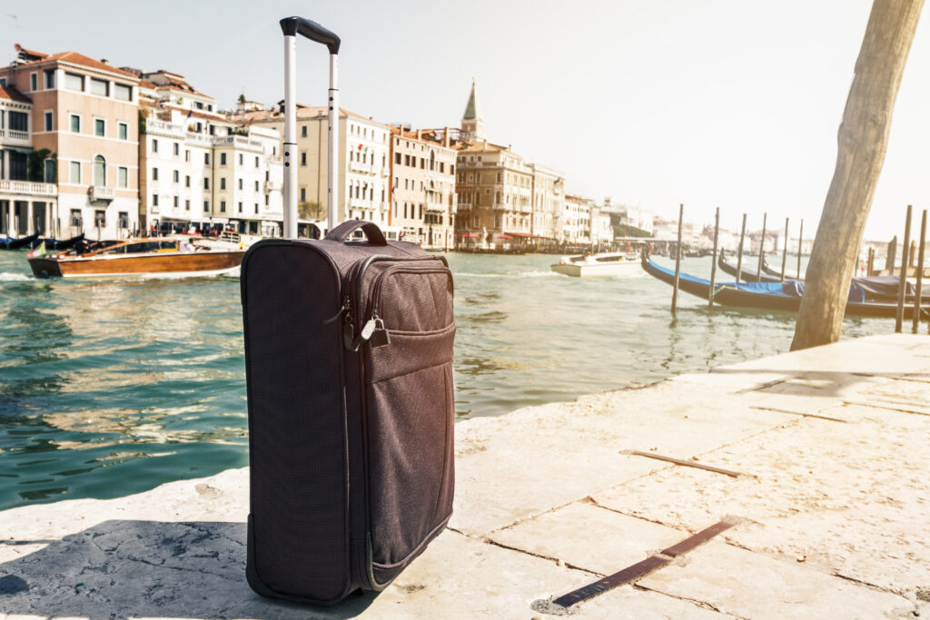 small suitcase travel urban background venice italy horizontal toning travel vacation concept